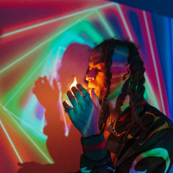 Man smoking in colorful lighting.